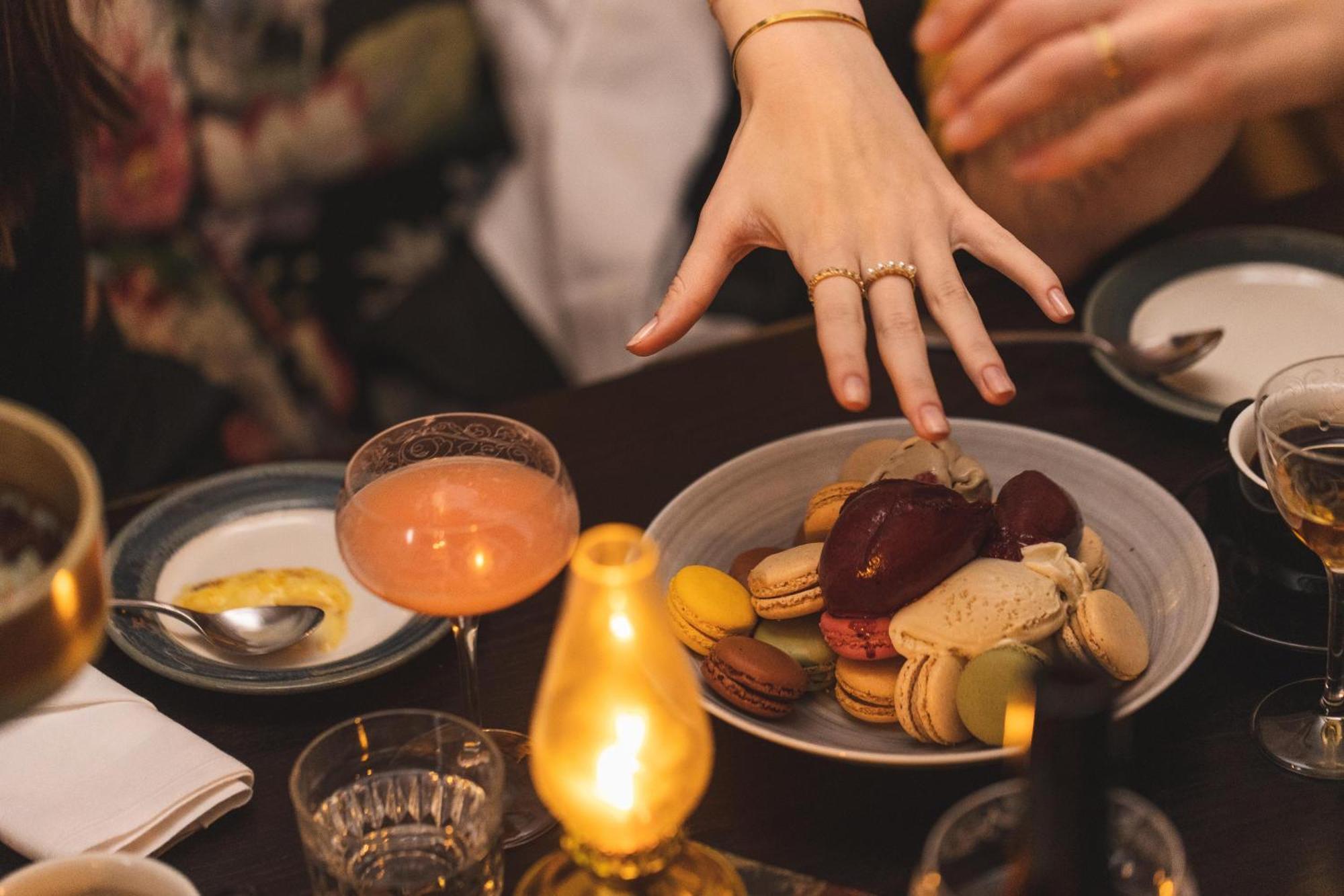 Hotel Pigalle Gothenburg Ngoại thất bức ảnh A woman's hand reaches for a plate of macarons